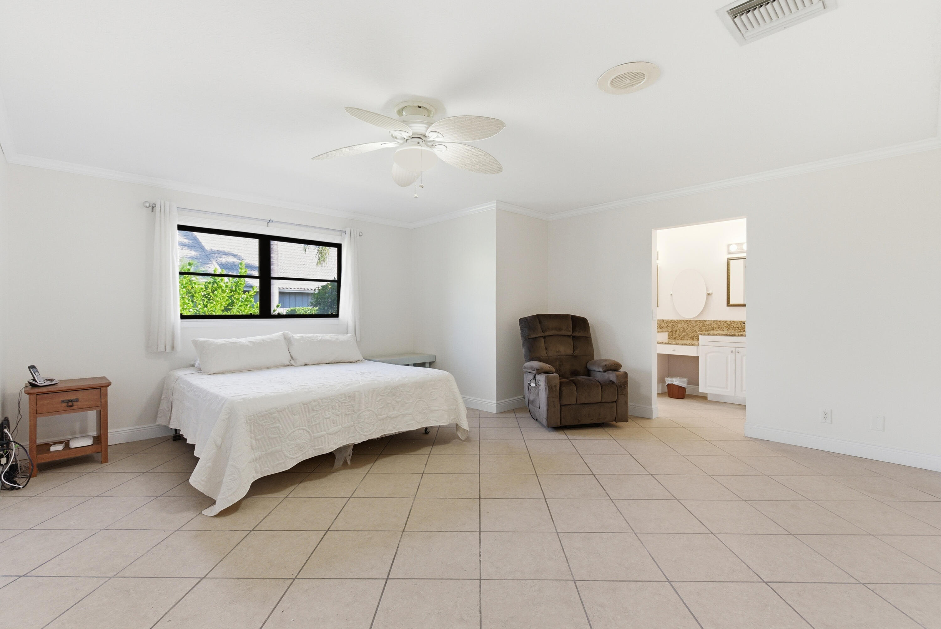 5151 Southeast Burning Tree Circle Stuart, FL 34997 - Photo 28 of 74 a spacious bedroom with a bed and a couch