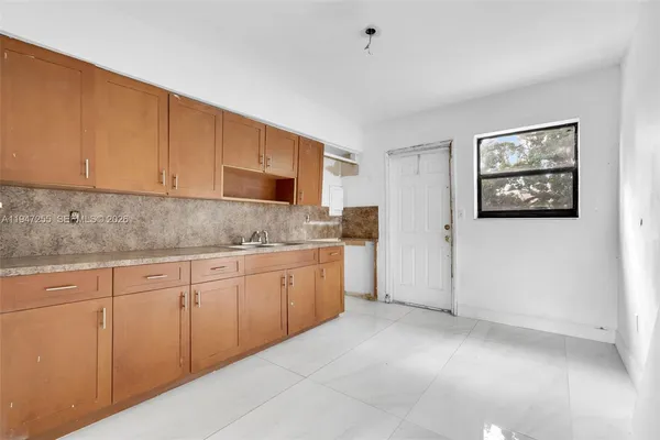 a kitchen with granite countertop white cabinets and stainless steel appliances