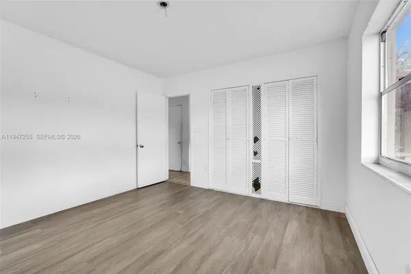 a view of an empty room with wooden floor