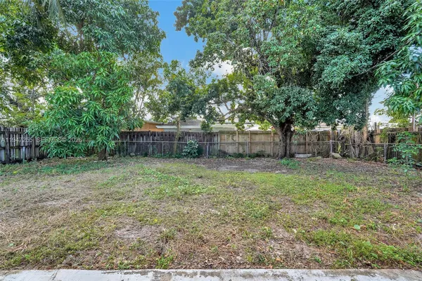 a backyard of a house with lots of plants and tree