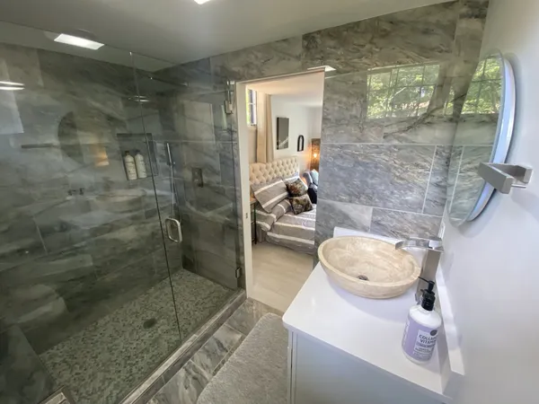 a bathroom with a sink a toilet a mirror and shower
