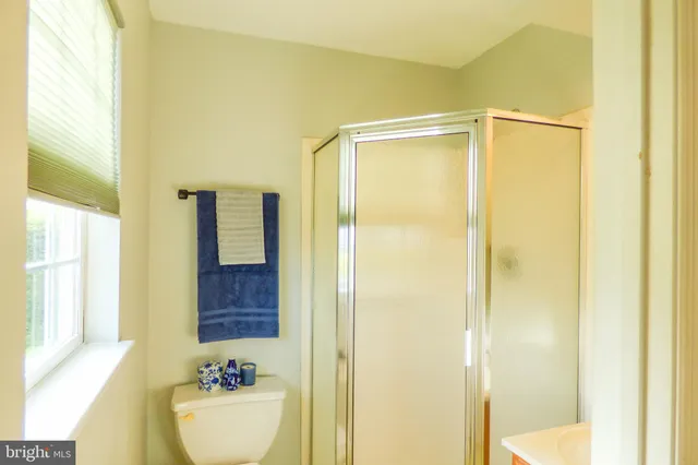 a bathroom with a shower curtain and a window