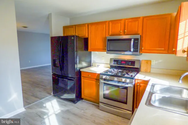 a kitchen with stainless steel appliances granite countertop a stove a microwave and a refrigerator