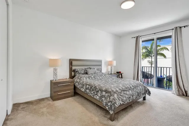 a bedroom with a bed lamp and a large window