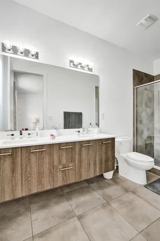 a bathroom with a double vanity sink mirror and toilet