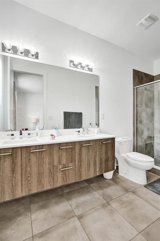 480 Northeast 35th Court, Unit 2 Oakland Park, FL 33334 - Photo 16 of 35 a bathroom with a double vanity sink mirror and toilet