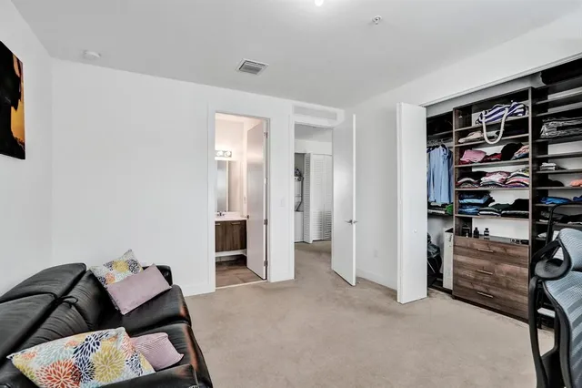 a view of a bedroom with furniture and closet
