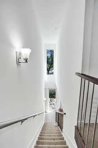 a view of a hallway with wooden floor and a potted plant
