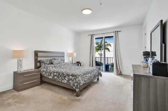 a bedroom with a bed and a flat tv screen on a dresser
