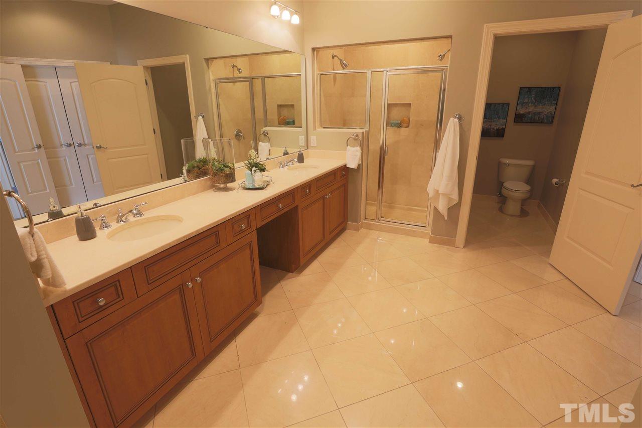 317 West Morgan Street, Unit 412 Raleigh, NC 27601 - Photo 13 of 25 a spacious bathroom with a double vanity sink a mirror and a bathtub