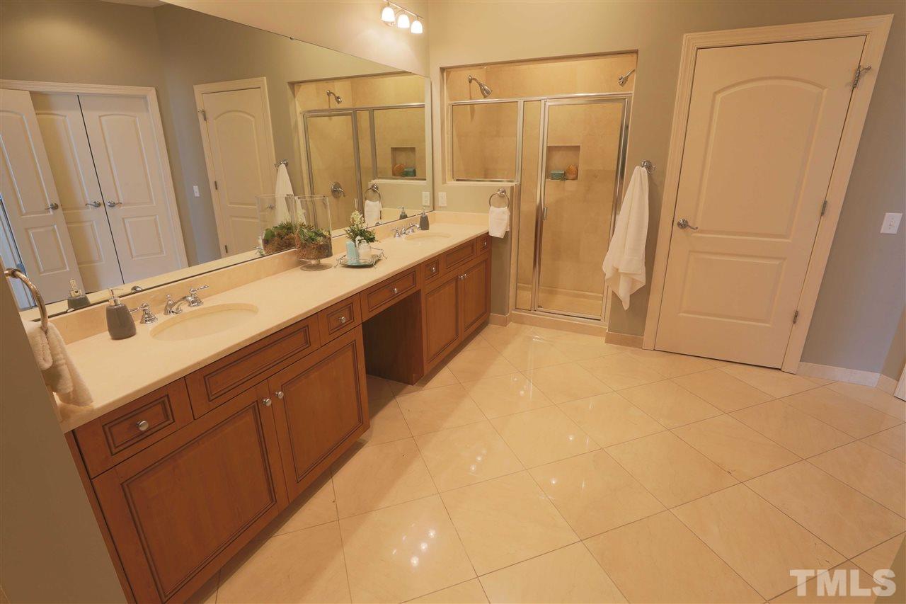 317 West Morgan Street, Unit 412 Raleigh, NC 27601 - Photo 15 of 25 a spacious bathroom with a double vanity sink a mirror and a bathtub