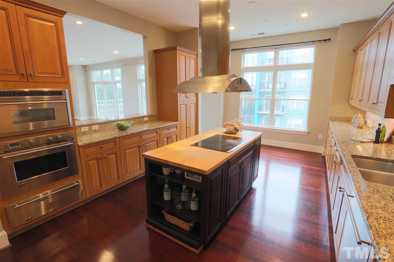 317 West Morgan Street, Unit 412 Raleigh, NC 27601 - Photo 5 of 25 a kitchen with stainless steel appliances granite countertop a stove a sink and a refrigerator