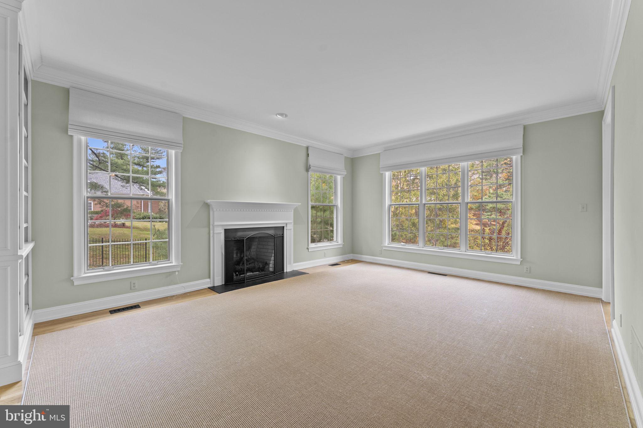 841 Mt Moro Road Villanova, PA 19085 - Photo 8 of 63 an empty room with a fireplace and large windows