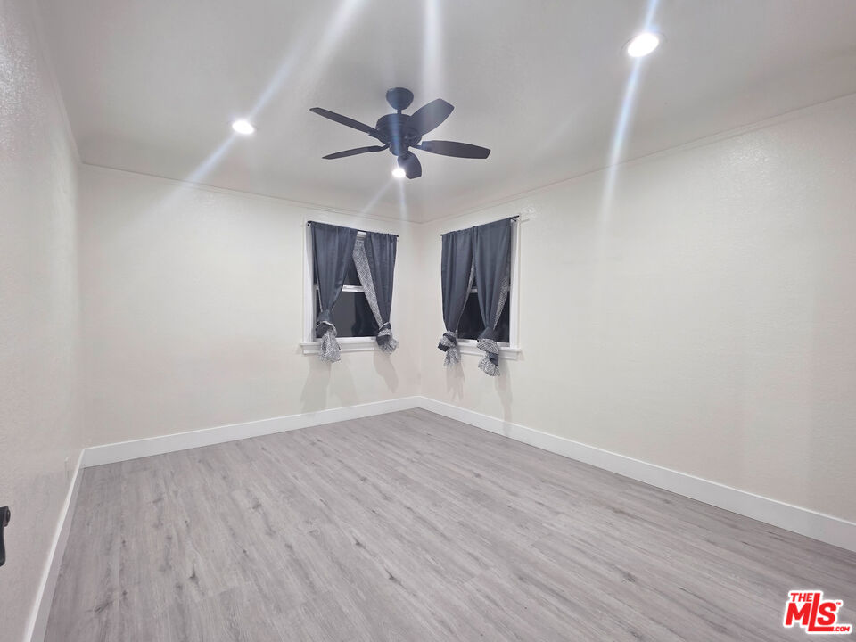 1111 North Spring Avenue Compton, CA 90221 - Photo 23 of 28 a view of an empty room with wooden floor and a ceiling fan