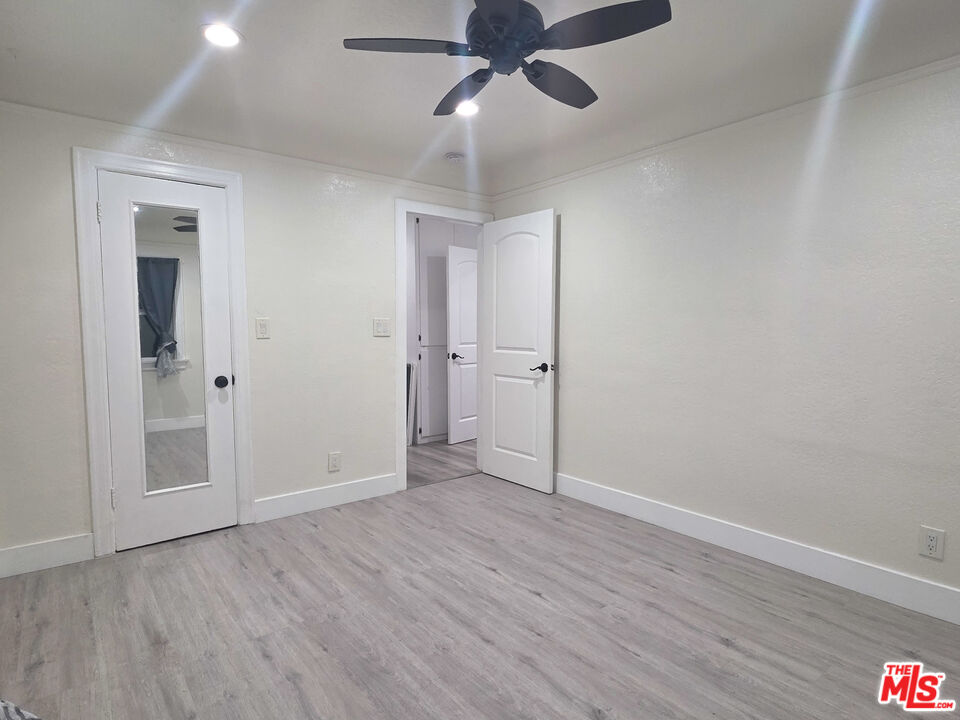 1111 North Spring Avenue Compton, CA 90221 - Photo 24 of 28 an empty room with wooden floor a ceiling fan and closet