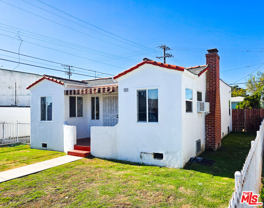 1111 North Spring Avenue Compton, CA 90221 - Photo 4 of 28 a view of a white house with a small yard and potted plants