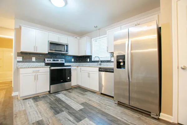 a kitchen with a refrigerator a sink and a stove top oven