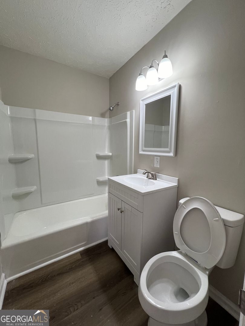 1695 East Broad Street, Unit A Athens, GA 30601 - Photo 11 of 13 a bathroom with a toilet a sink a mirror and bathtub
