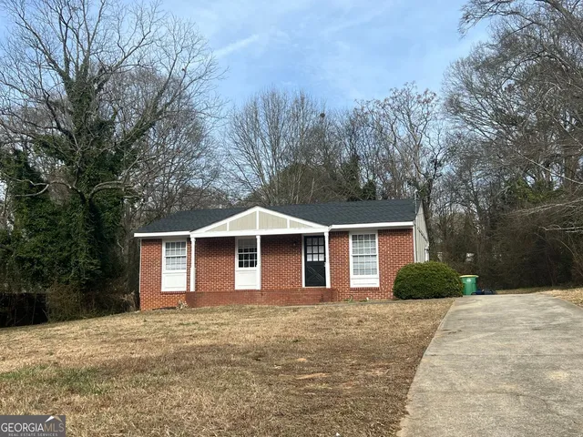a front view of a house with yard and trees
