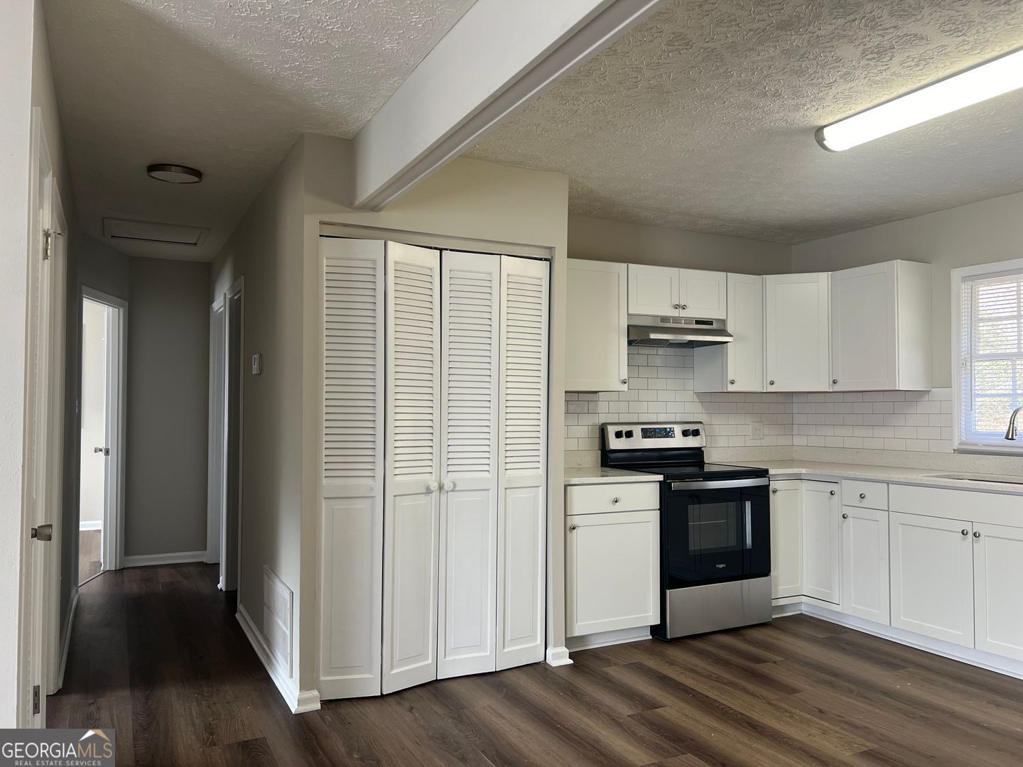 1695 East Broad Street, Unit A Athens, GA 30601 - Photo 6 of 13 a kitchen with stainless steel appliances granite countertop a stove a sink and white cabinets