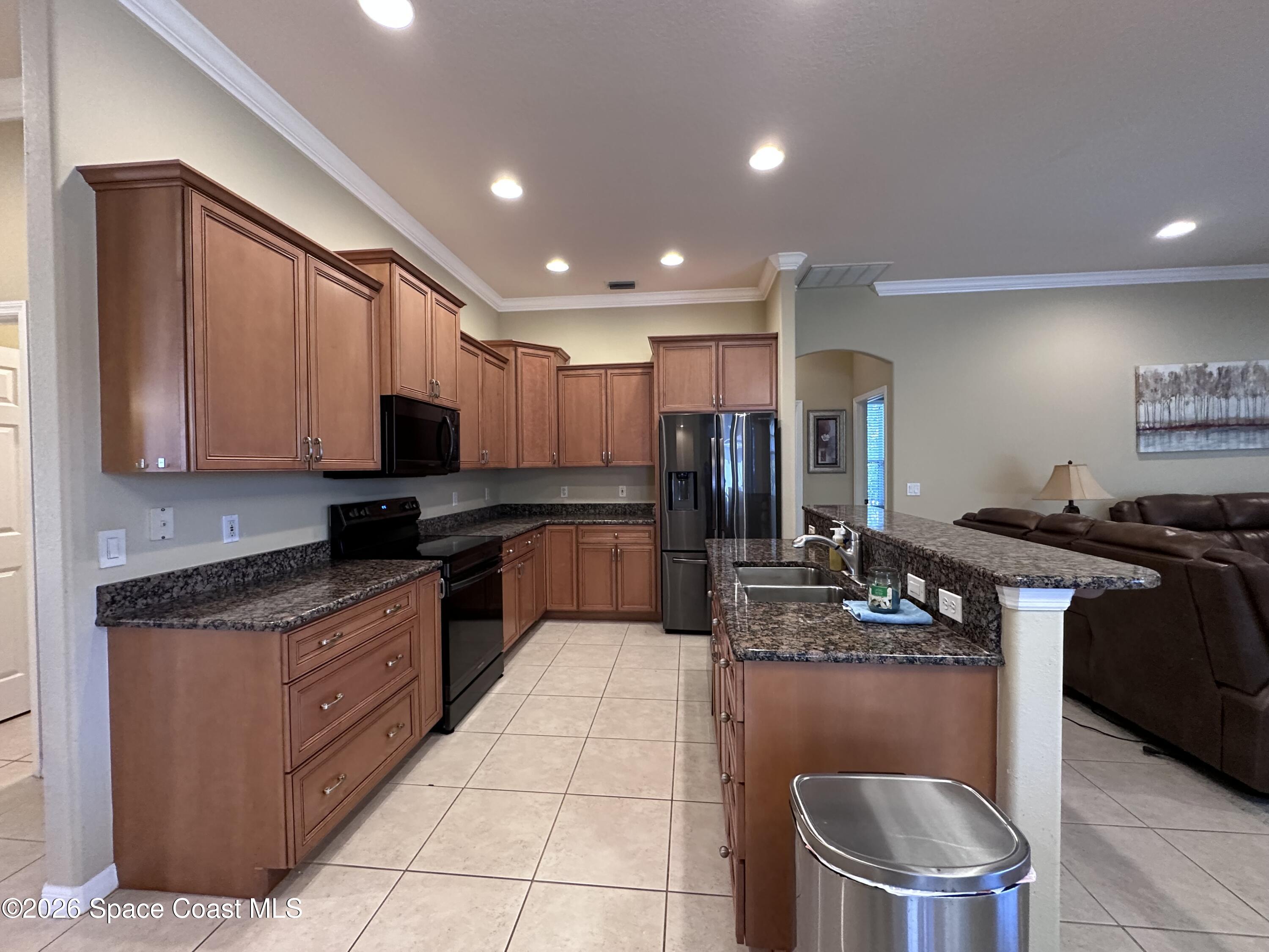 883 Spring Oak Drive Melbourne, FL 32901 - Photo 15 of 45 a kitchen with stainless steel appliances granite countertop a sink a stove and cabinets