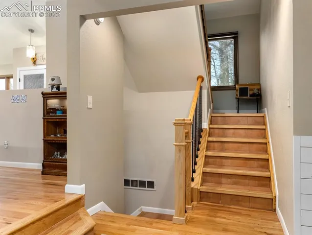 a view of a bedroom with wooden floor and stairs