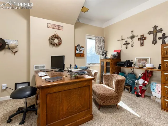 a view of a workspace with furniture and a window