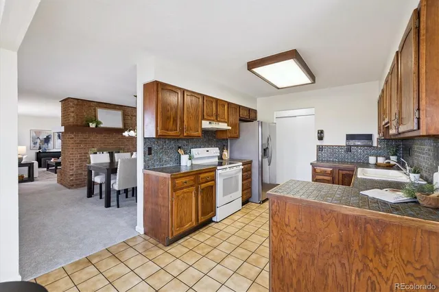 a kitchen with stainless steel appliances granite countertop a stove refrigerator sink and cabinets