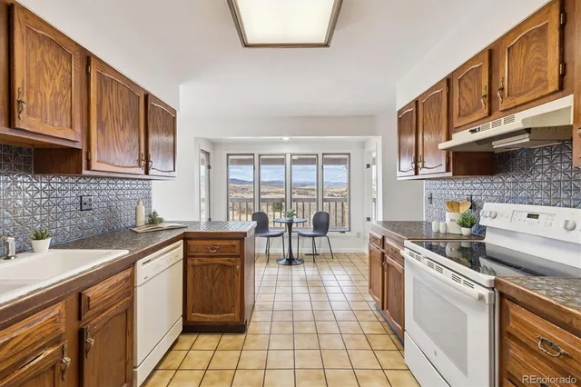 a kitchen with stainless steel appliances a sink a stove top oven a counter space and cabinets