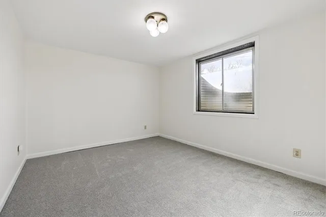 an empty room with a fireplace and windows