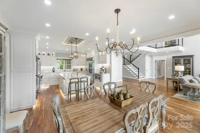 a view of a dining room and livingroom with furniture wooden floor kitchen view
