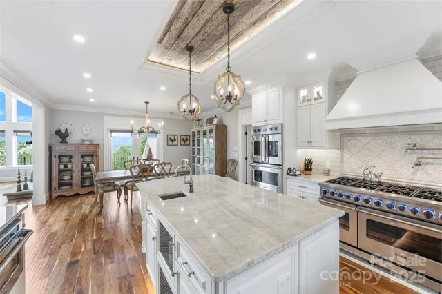 a kitchen with stainless steel appliances granite countertop a stove and a wooden floors
