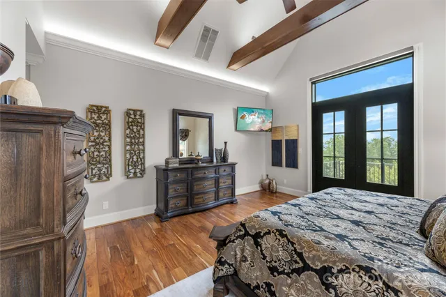 a bedroom with a bed dresser and a large window