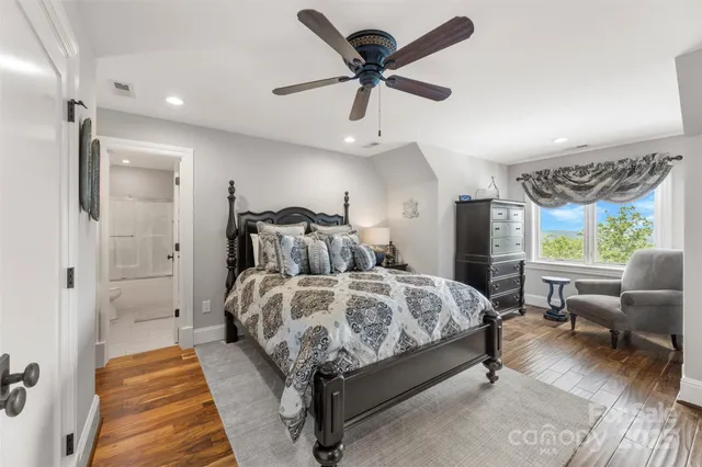 a spacious bedroom with a bed a couch and a ceiling fan