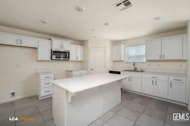 a kitchen with cabinets appliances a sink and a counter top space