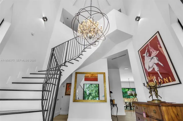 a living room with furniture a flat screen tv and a chandelier