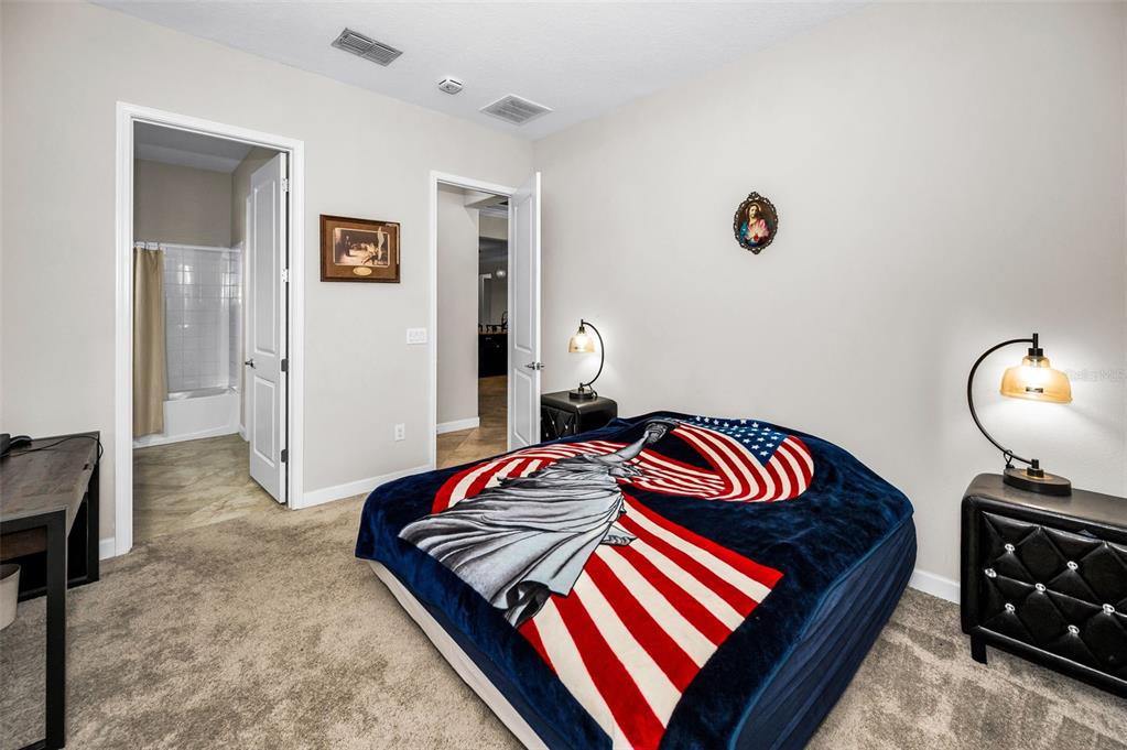 16833 Banner Shell Place Wimauma, FL 33598 - Photo 24 of 55 a bedroom with a bed and a lamp