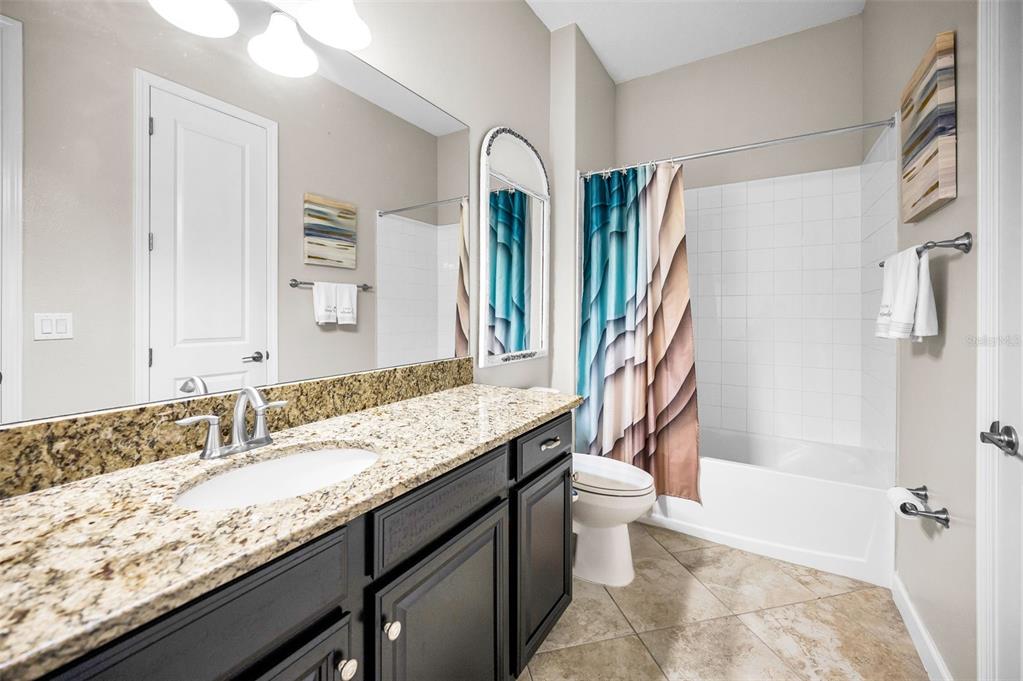 16833 Banner Shell Place Wimauma, FL 33598 - Photo 27 of 55 a bathroom with a granite countertop sink toilet and shower
