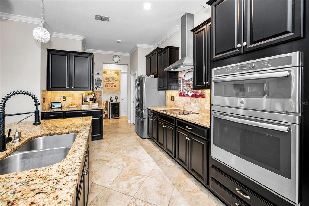 16833 Banner Shell Place Wimauma, FL 33598 - Photo 7 of 55 a kitchen with kitchen island granite countertop a stove cabinets and microwave