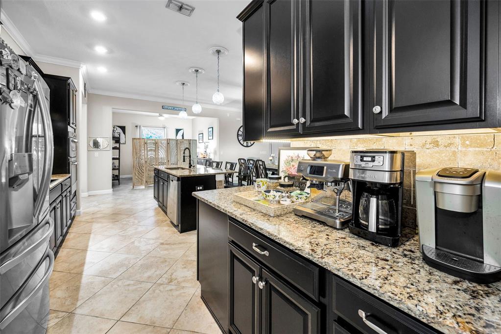 16833 Banner Shell Place Wimauma, FL 33598 - Photo 10 of 55 a kitchen with stainless steel appliances granite countertop a sink stove and refrigerator