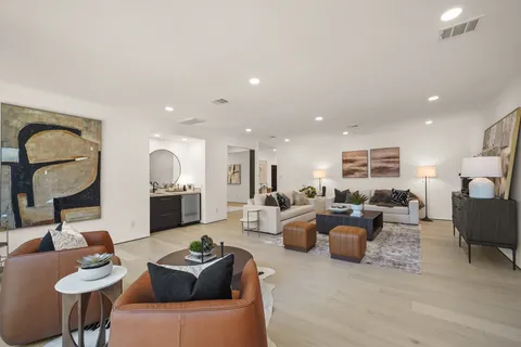 a living room with furniture a rug and white walls
