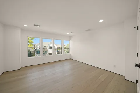 an empty room with furniture and large windows