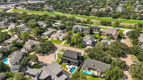 an aerial view of residential houses with outdoor space and street view