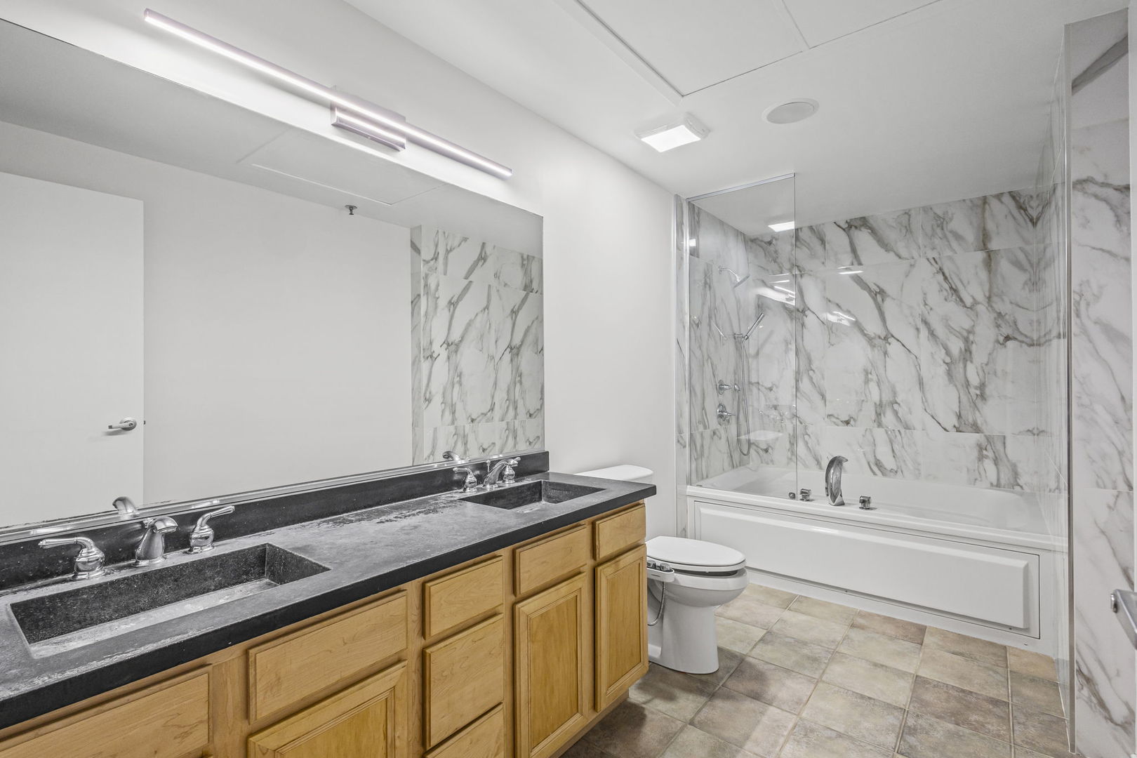 1530 South State Street, Unit 706 Chicago, IL 60605 - Photo 17 of 24 a bathroom with a granite countertop sink toilet and shower