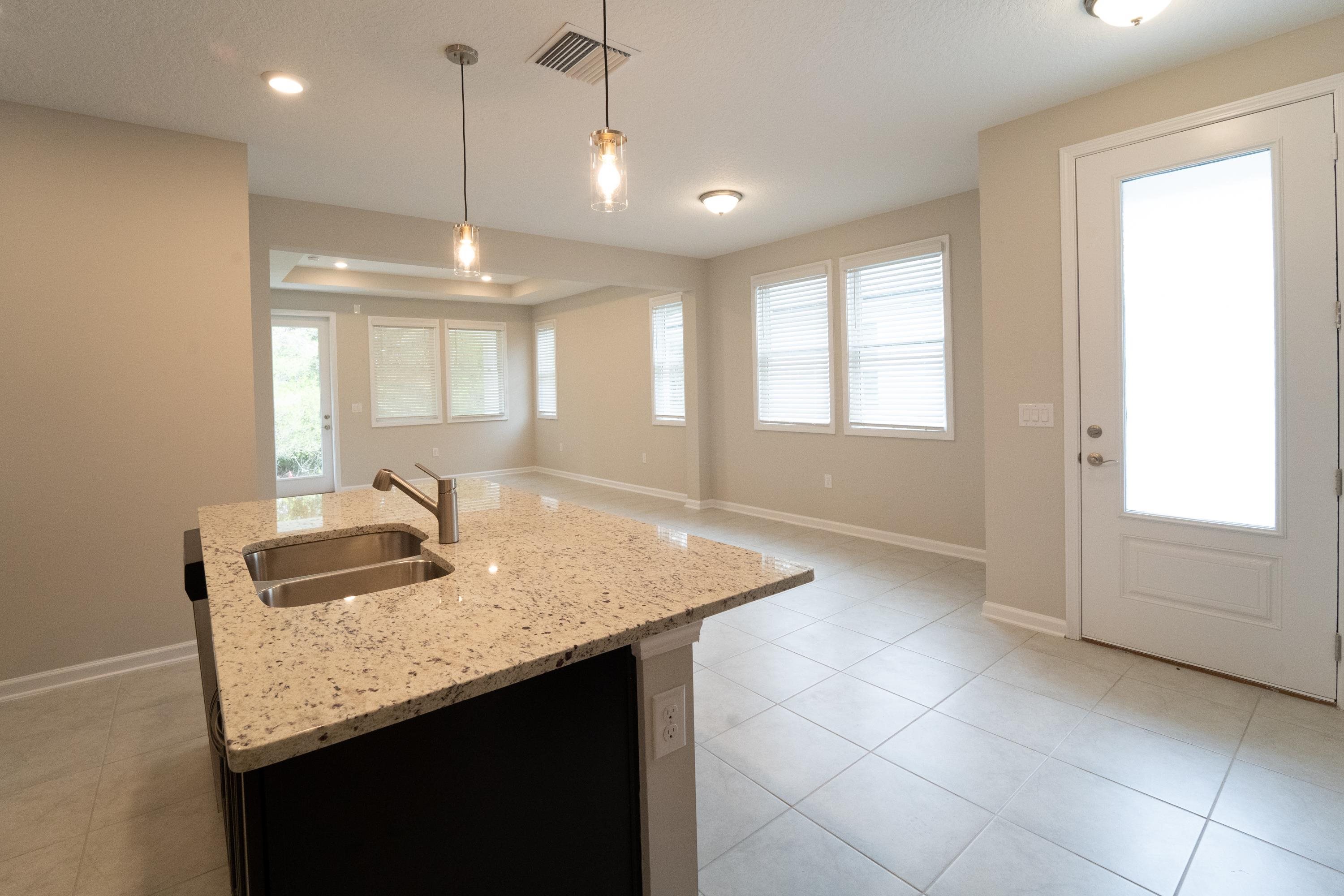 298 Modesto Drive St. Augustine, FL 32086 - Photo 17 of 28 a kitchen with kitchen island granite countertop a sink a counter top space and cabinets