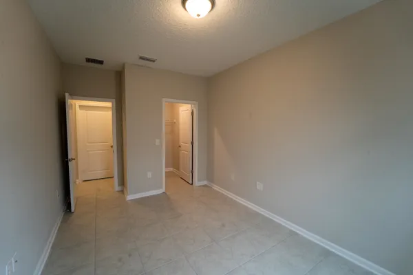 an empty room with windows and closet