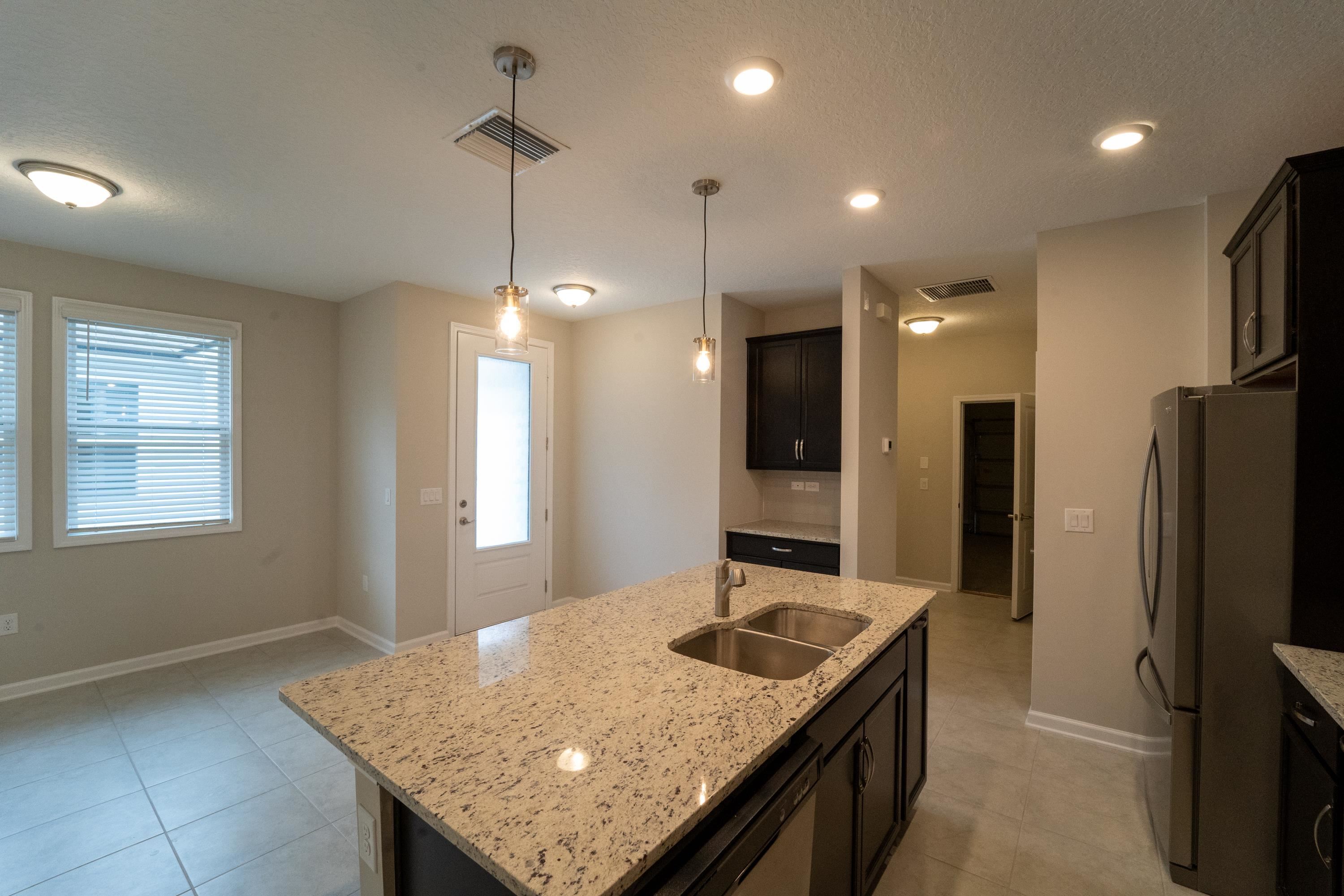 298 Modesto Drive St. Augustine, FL 32086 - Photo 2 of 28 a kitchen with a kitchen island a sink stove and refrigerator
