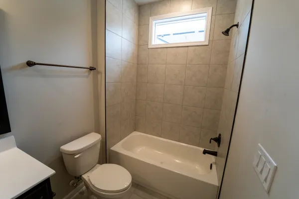 a white toilet sitting next to a bath tub
