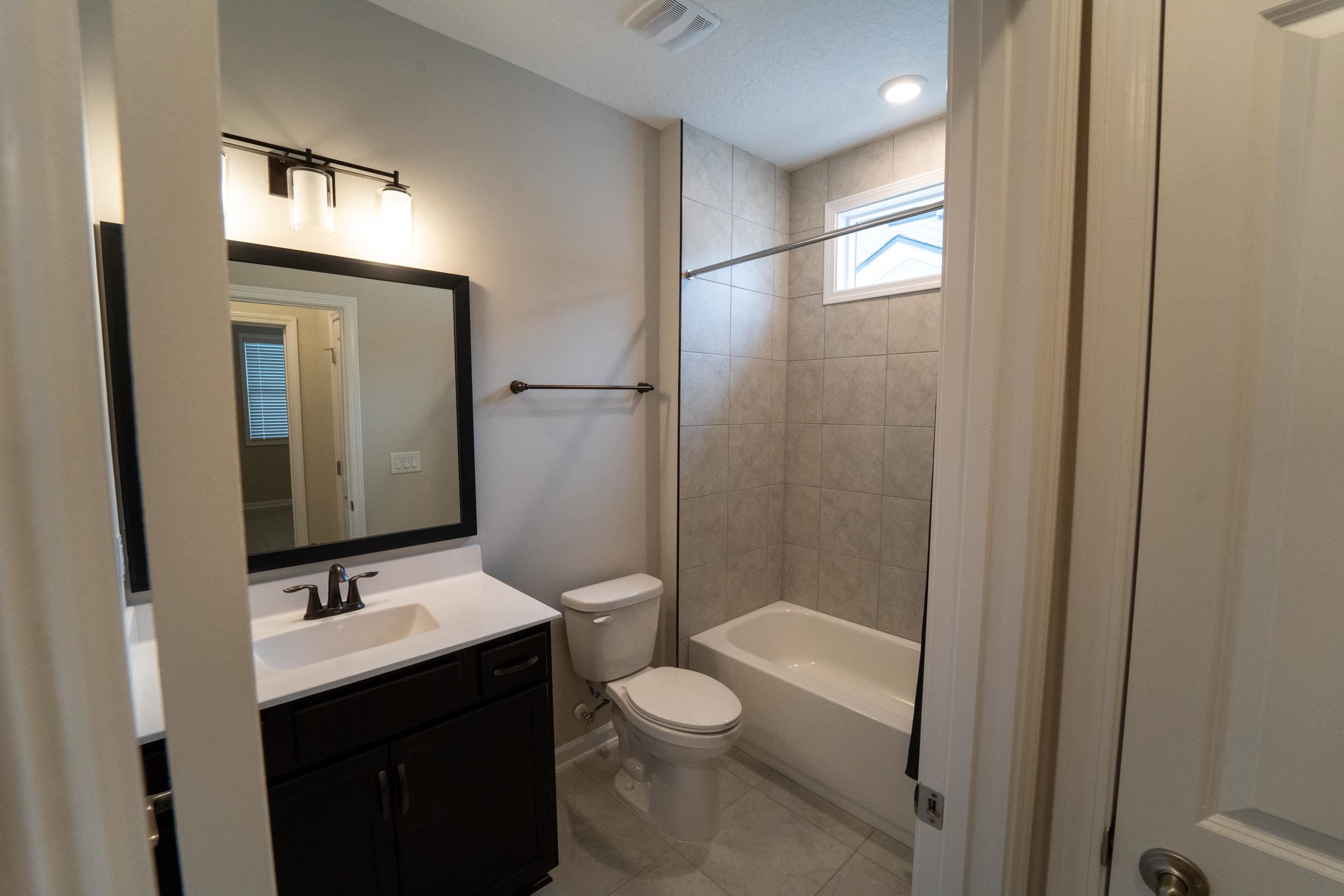 298 Modesto Drive St. Augustine, FL 32086 - Photo 24 of 28 a bathroom with a granite countertop sink toilet a mirror and shower