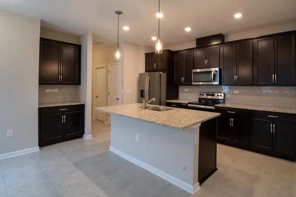 a kitchen with kitchen island granite countertop stainless steel appliances kitchen island granite countertop a stove and a sink